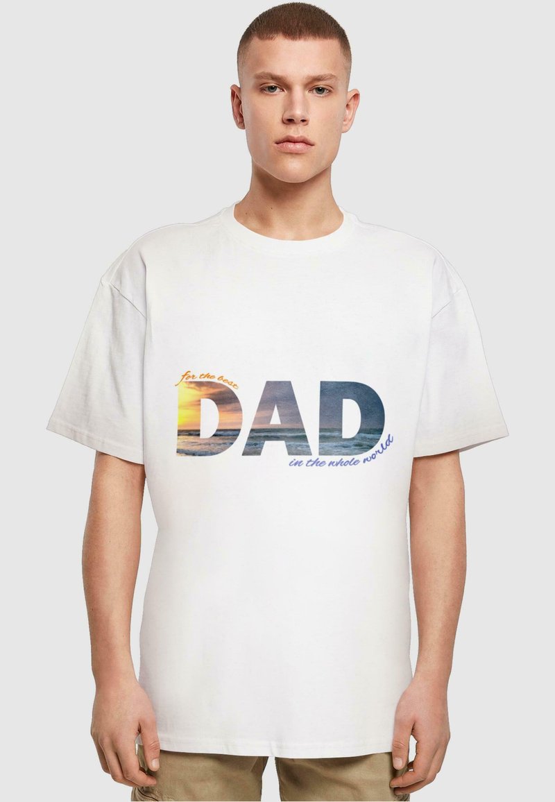 Witte katoenen T-shirt met een afbeelding waarop de tekst "voor de beste VIDA ter wereld" staat, over een afbeelding van een zonsondergang op het strand.