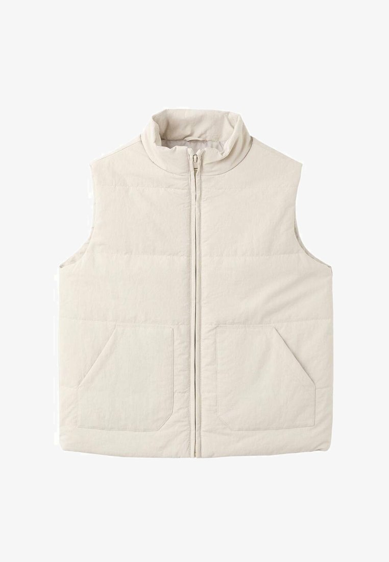 Světlé béžová vesta bez rukávů s vysokým límcem, předním zipem a dvěma velkými našitými kapsami. Má prošívané detaily po celé látce.
