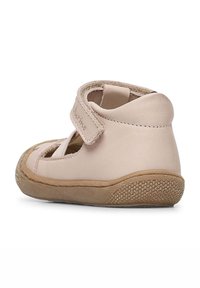 Zapato de cuero para toddler en color rosa claro con puntera redondeada, diseño troquelado, correa de Velcro ajustable y suela de goma texturizada.