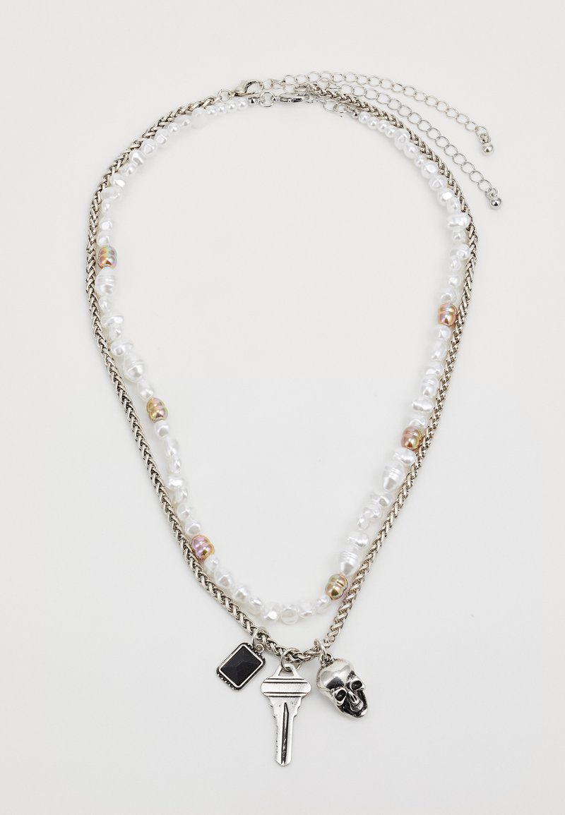 Silver chain necklace with layered design, featuring pearl beads, a black charm, a key pendant, and a skull detail.