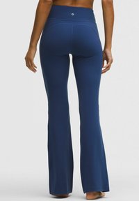 Marinblå utsvängda leggings gjorda av ett mjukt, elastiskt material med hög midja och subtila sömdetaljer.