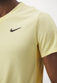 Nike Performance TOP - Camiseta deportiva - soft yellow/topaz gold/black