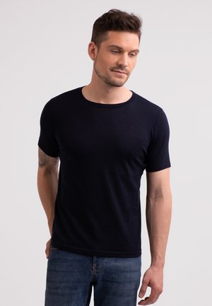 Navy blue short-sleeve t-shirt made from lightweight fabric, featuring a crew neckline and a smooth texture. Worn with denim jeans.