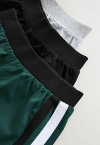 Katoenen sportshorts in donkergroen, zwart, grijs en wit, met elastische taillebanden en gestreepte accenten op het donkergroene paar.