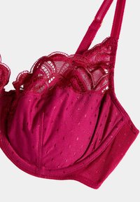Fuchsia bh met kantafwerking en stippenpatroon; zachte stof; verstelbare bandjes; onderbuststeun; gedetailleerde stiksels langs de randen.