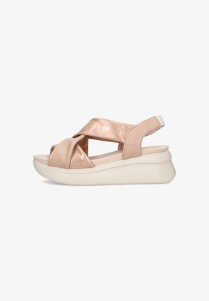 Sandalo con zeppa con cinturini incrociati in pelle beige e suola bianca imbottita, punta aperta e cinturino sul tallone.