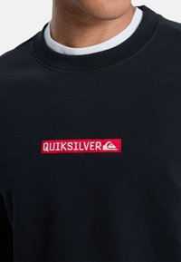Zwarte sweatshirt met een ronde hals en geribde mouwen, met een opvallend rood geborduurd "QUIKSILVER" logo op de borst.