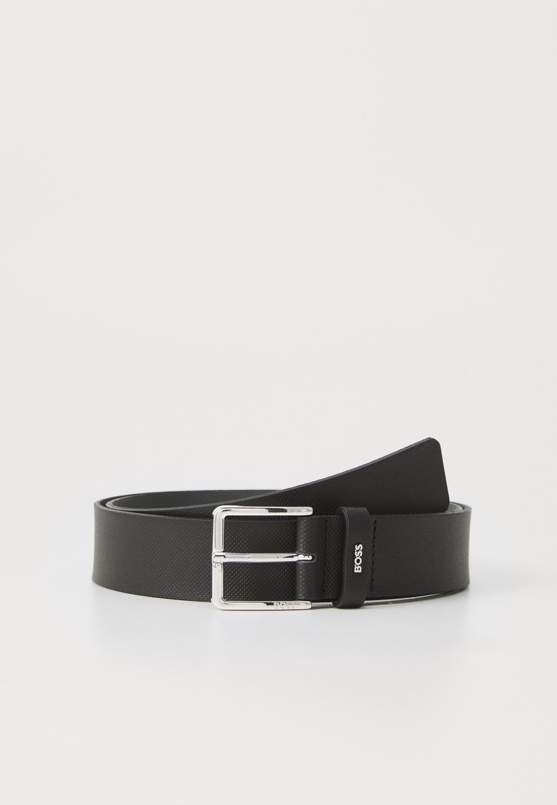 Cinturón sintético negro con un acabado texturizado, que presenta una hebilla de metal plateado y un acento de logotipo en la correa. Diseñado para un ajuste ajustable.