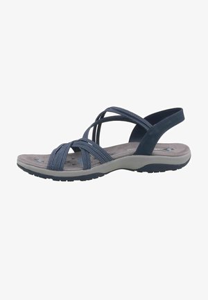 Sandales marine avec des brides croisées en tissu texturé. Elles disposent d'une semelle rembourrée et d'une semelle extérieure en caoutchouc flexible. Coutures de détail visibles.