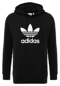 Felpa con cappuccio Adidas nera con grande logo trefoil bianco e nome del marchio sul davanti, tasca a marsupio e cappuccio con coulisse.