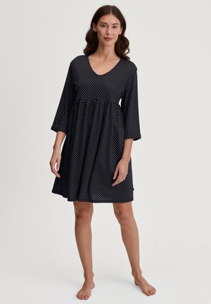 Abito corto nero con pois bianchi, scollatura a V, maniche a tre quarti e vita arricciata, realizzato in tessuto leggero.