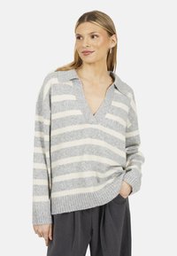Maglione a strisce grigie e crema con scollatura a V e colletto oversize. Presenta polsini e orlo a coste, realizzato in un morbido materiale misto lana.