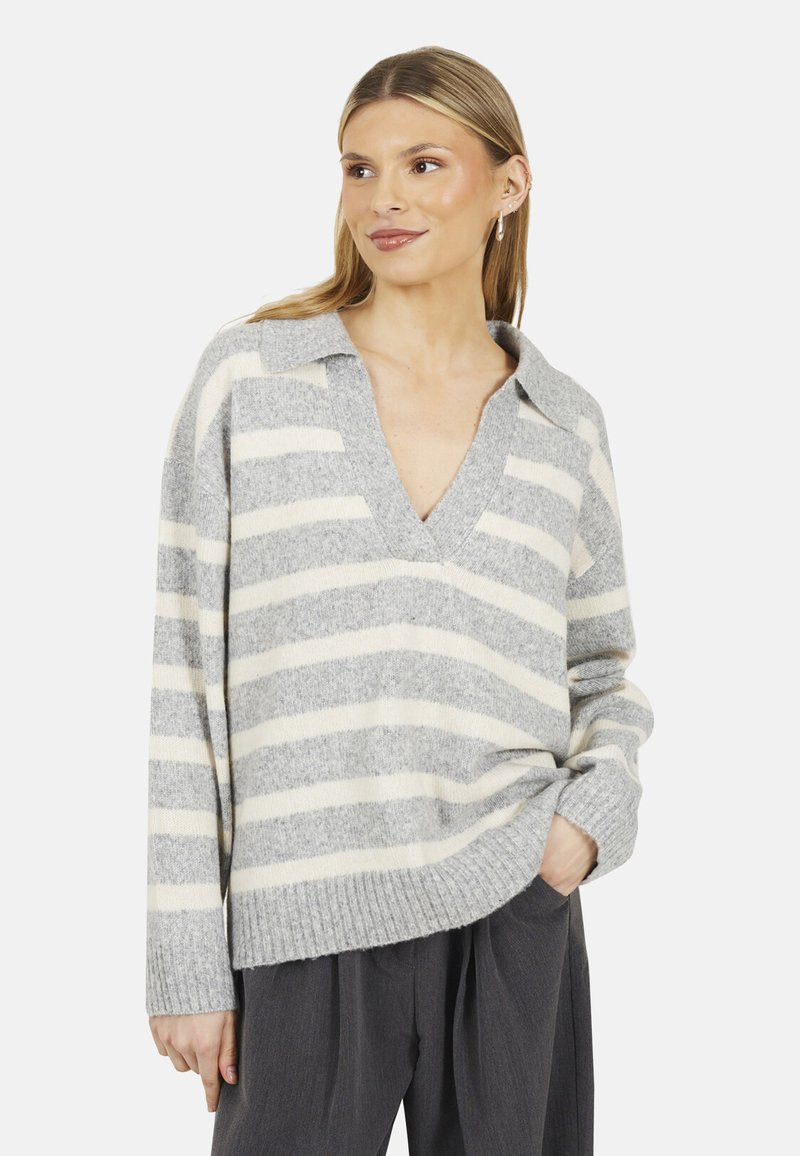 Maglione a strisce grigie e crema con scollatura a V e colletto oversize. Presenta polsini e orlo a coste, realizzato in un morbido materiale misto lana.