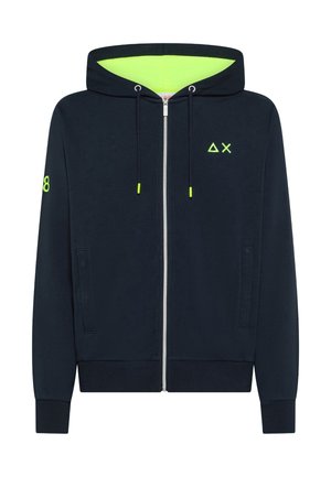 Felpa con cappuccio con zip color blu navy, con interno del cappuccio verde neon, estremità del cordino, piccolo logo a triangolo e X sul petto, e numero 8 sulla manica sinistra.