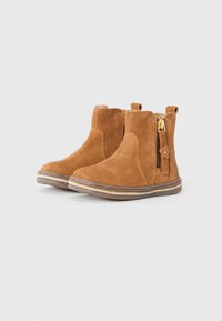 Botas de tobillo de ante marrón con cremalleras laterales, adornos decorativos de flores, puntera redonda y una suela de goma texturizada con detalles estratificados.