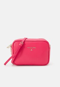 Różowa skórzana torba na ramię z zamkiem błyskawicznym, złotymi okuciami oraz wytłoczonym logo na przedniej stronie. Posiada odpinany pasek.