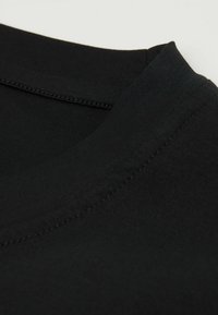 Zwarte katoenen t-shirt kraag, met een ronde halslijn en een zachte textuur, met zichtbare stiksels langs de randen.