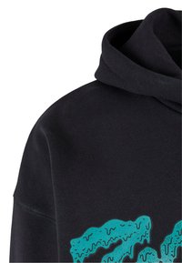 Black hoodie with a textured green print featuring drips and splatters. The fabric appears soft, with a close-fitting hood and stitching detail.