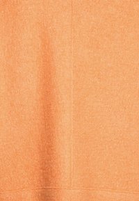 Tissu orange texturé avec une finition douce ; présente des lignes et des coutures subtiles. Le matériau semble confortable et chaud.