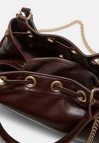 Borsa a tracolla in pelle marrone con hardware dorato, tracolla a catena e tasca con zip. L'interno presenta più scomparti e una texture liscia.