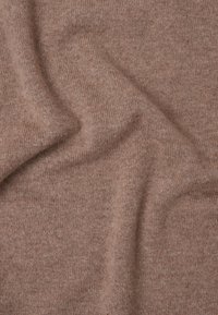 Braun gestrickter Stoff mit einer weichen Textur, der eine glatte, gleichmäßige Oberfläche und subtile Farbvariationen aufweist.