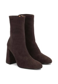 Stivali alla caviglia in suede marrone con punta affilata e tacco a blocco. Presentano un design senza cuciture e una cerniera laterale per una facile vestibilità.