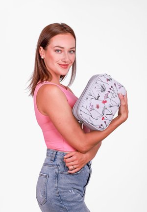 Kosmetická taštička s květinovým vzorem v světle šedé barvě, s růžovými a purpurovými akcenty. Strukturovaný tvar s dvojitým zipem.