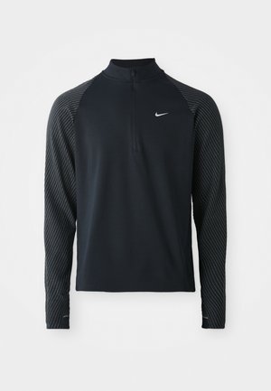 Črn atletski dolg rokav s pol-zadrgo, s temno sivo raglan rokavi s vzorcem in majhnim belim logotipom Nike na prsih.