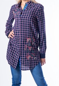 Camicia a quadri nautici e magenta con bottoni, caratterizzata da ricami floreali sulla parte anteriore, maniche lunghe e un design con orlo curvo.