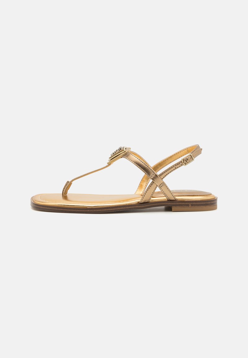Guldiga platta sandaler med tåpostdesign, korsade remmar och dekorativ spänne, med en slät läderfinish och låg klack.