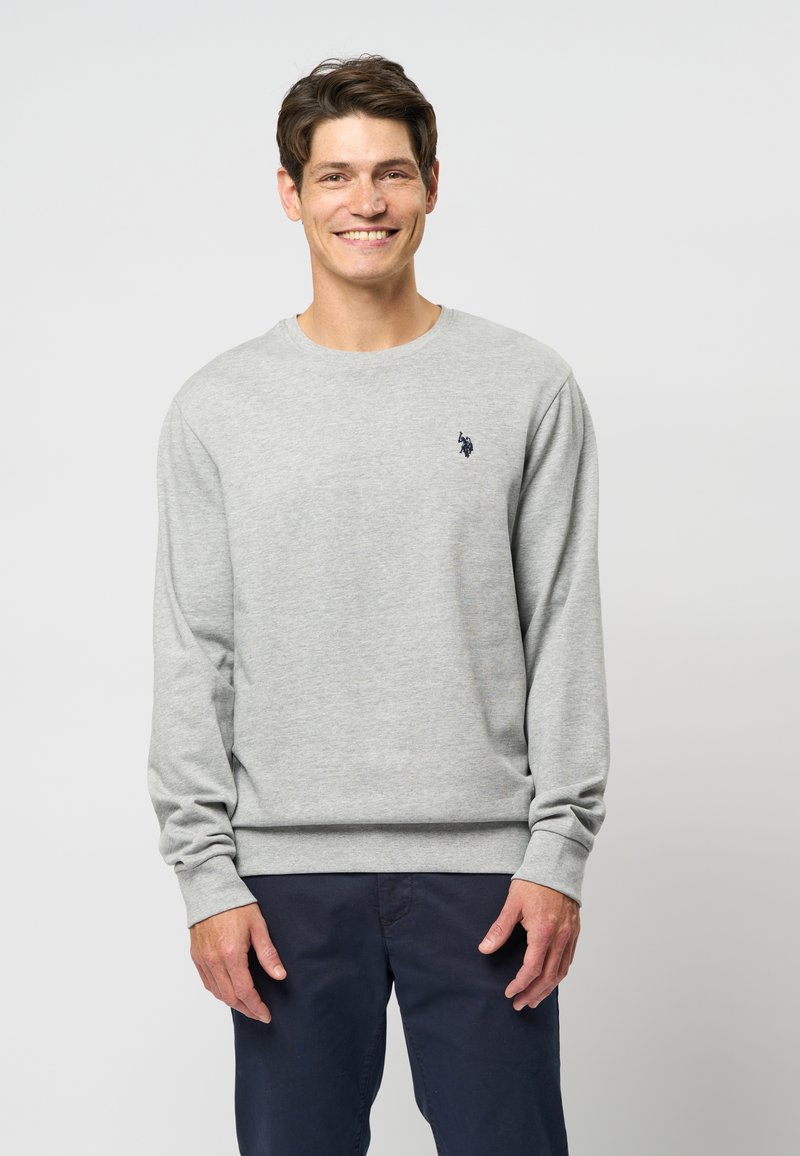 Sweatshirt gri cu mâneci lungi, guler rotund și manșete ribbate. Prezintă un mic logo bleu marin pe piept și are o croială normală.