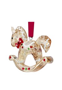 En kristallberidet gungande hästprydnad med en transparent gyllene nyans, accentuerad med en röd rosett, gröna och röda prickar samt ett röd band för upphängning.