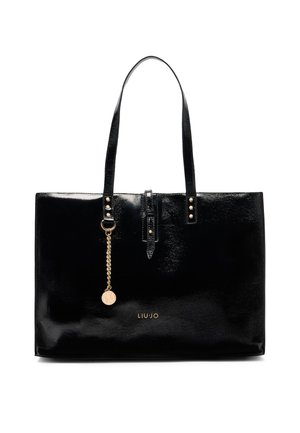 Sac fourre-tout en cuir verni noir avec deux poignées, accents dorés, une chaîne décorative et un logo sur le devant. Texture lisse.