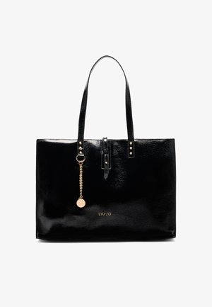 Borsa tote in pelle sintetica nera con due manici, dettagli in acciaio dorato, una catena decorativa e logo sul davanti. Texture liscia.