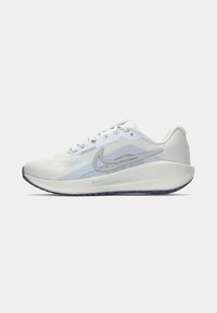 Lett Nike joggesko i hvitt med lyseblå detaljer, mesh-overdel, polstret såle og fremtredende swoosh-logo, sidevinkel.
