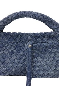 Vävd denimhandväska i mörkblått med ett flätat handtag och strukturerad yta; har ett litet ficka med en nitar detalj.
