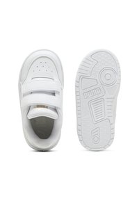 Sneaker bianchi con due cinturini in velcro, tomaia testurizzata, punta perforata e suola in gomma con motivo che presenta un logo.