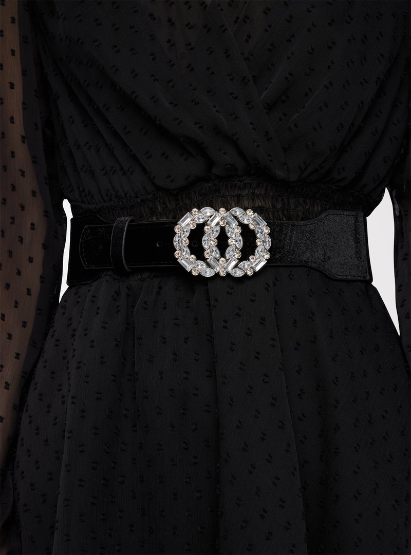 Vestito nero con texture, stretto in vita da una larga cintura in velluto nero con fibbia doppio cerchio impreziosita da pietre chiare.