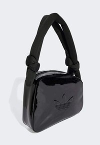 Black patent leather handbag with a knotted black fabric handle, featuring embossed logo detail on the front and a zippered closure.