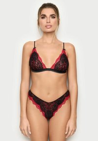 Bralette in pizzo nero e rosso con spalline regolabili, caratterizzato da motivi floreali e bordi scallop, abbinato a un perizoma coordinato.