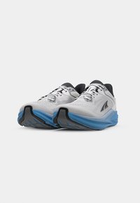 Chaussures de course pour hommes en mesh gris avec semelle en caoutchouc bleue. Présente des accents noirs et des éléments réfléchissants. Conçues pour le confort et le soutien.