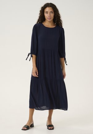 Robe bleu marine, longueur genou, à manches trois-quarts, design en étages et détails à nouer sur les manches, fabriquée en tissu léger.
