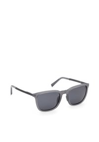 Lunettes de soleil rectangulaires grises avec des verres polarisés foncés et des branches fines, inclinées sur un fond blanc.