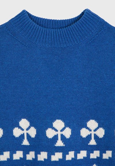 Blauer Strickpullover mit geripptem Rundhalsausschnitt und weißen Vereins-Anzug-Symbolen, die über die Brust verteilt sind.
