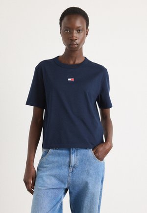 Marineblå bomulds t-shirt med korte ærmer og rund halsåbning, med et lille logo-patch på brystet. Løs pasform med en glat tekstur.