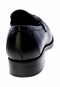 Scarpa da uomo nera in pelle con tacco basso impilato e dettagli cuciti, vista dal retro su uno sfondo bianco.