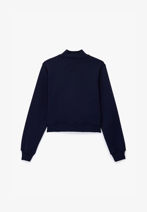 Granatowy krótkiego kroju sweter z wysokim kołnierzem, długimi rękawami i ściśniętymi mankietami, charakteryzujący się gładką, miękką fakturą. Widok z tyłu.