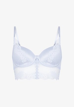 Soutien-gorge en dentelle blanche avec bonnets rembourrés, bretelles réglables et fermeture frontale à boutons, présentant des détails en dentelle florale sur les bonnets et la bande.