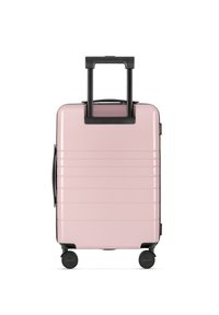 Walizka twarda w jasnoróżowym kolorze z pionowymi bruzdami, podwójnymi czarnymi kółkami, wysuwaną rączką i boczną rączką do noszenia.