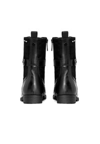 Las botas negras hasta el tobillo presentan una combinación de ante texturizado y cuero suave, con doble cremallera, detalles de correas ajustables y un tacón bajo.